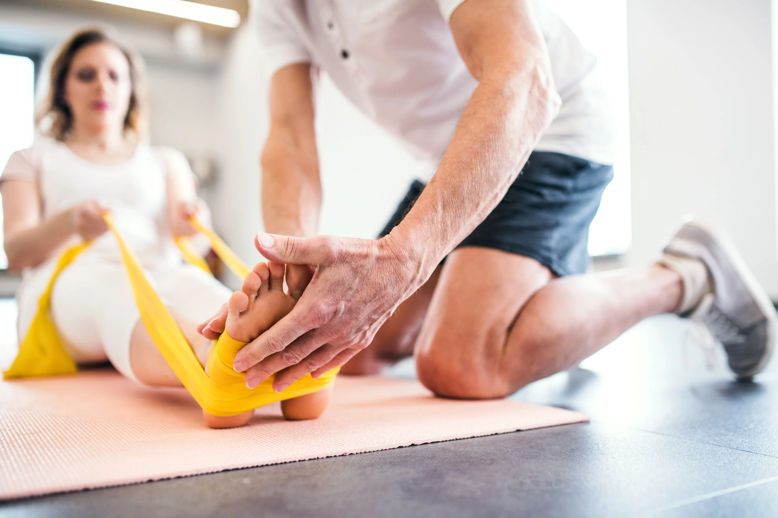 Physical therapy session — therapist helping patient with knee exercises